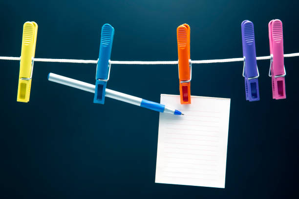 istock paper notepad for reminder and pen hanging on colored clothespins 1322780042