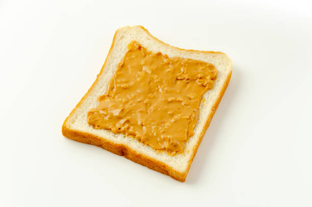 istock peanut butter on a slice of white bread. 1322782293
