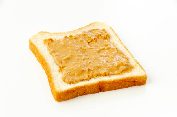 istock peanut butter on a slice of white bread. 1322782366