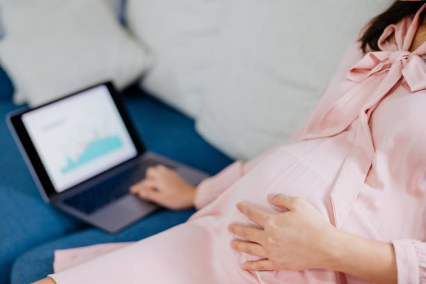 istock Asian mother to be using laptop and working at home 1322784113