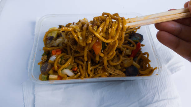 istock javanese fried noodles in plastic container being picked by asian man hand with chospticks 1322789769