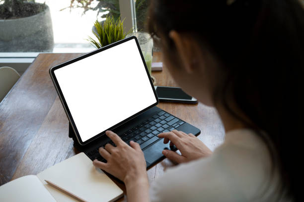 istock Back view young woman surfing internet with computer tablet. 1322794765