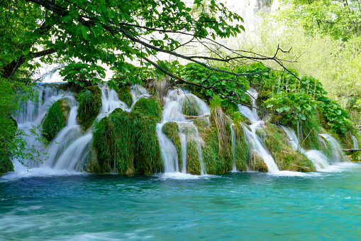 Plitvice Lakes National Park waterfall landscape with turquoise blue and green water in Croatia.\nD.H