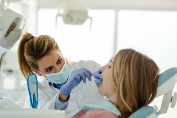 Perfect smile!Female dentist is examining her beautiful patient in dentistâs office. stock photo