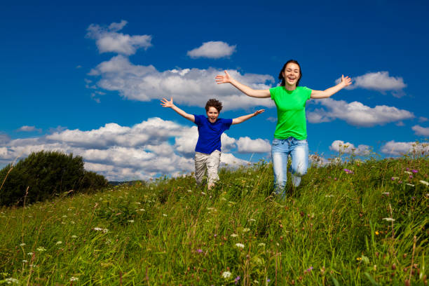 istock Girl and boy running on green meadow 1322800932
