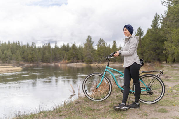 femme pleine d’espoir luttant contre le cancer à vélo - mental health women asian ethnicity bicycle photos et images de collection