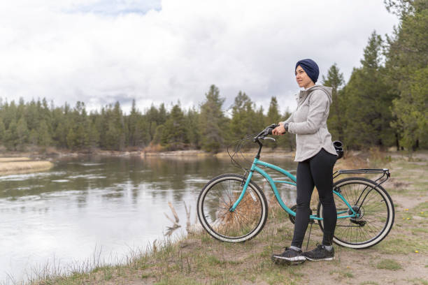 자전거 타기에 암과 싸우는 희망적인 여성 - mental health women asian ethnicity bicycle 뉴스 사진 이미지