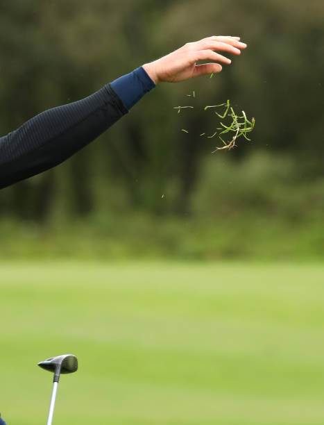 그녀의 샷을 촬영하기 전에 바람의 방향을 확인하는 인식 할 수없는 여성 골퍼. - golf golfer examining wind 뉴스 사진 이미지