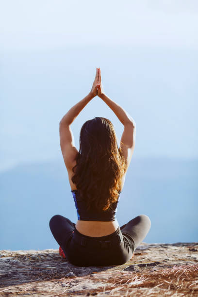 istock back view asian woman doing yoga at the mountain 1322808775
