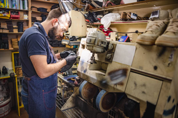 istock Cobbler wearing protective gloves and eyewear working on polishing machine 1322810268