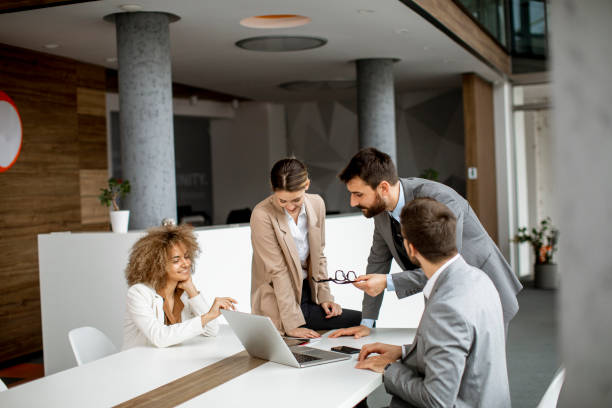 istock Group of young business people working and communicating while sitting at the office desk together 1322810319