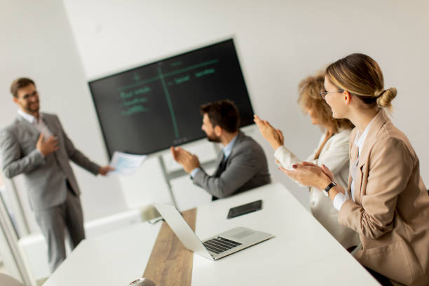 istock Group of young business people working and communicating while sitting at the office desk together 1322810330