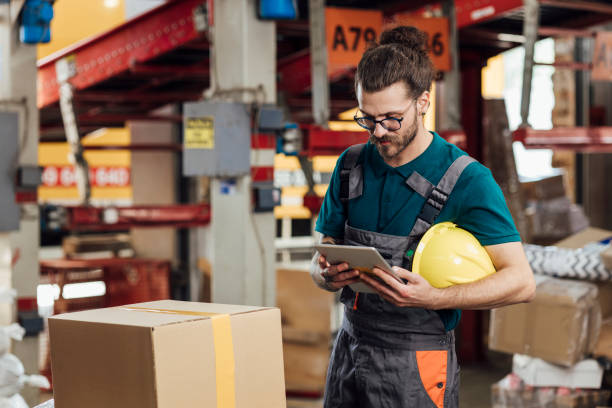 istock Young warehouse worker storing goods and checking it on a tablet 1322811049