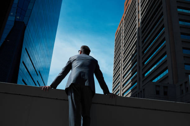 foto de un hombre de negocios maduro apoyando sus brazos contra una pared en la ciudad - rear view men business back fotografías e imágenes de stock