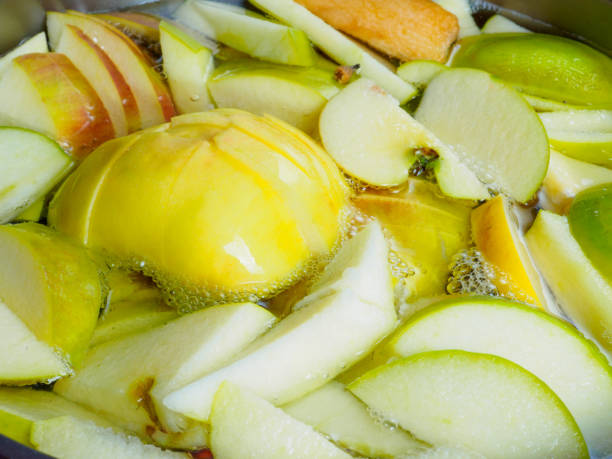 The process of cooking compote. Close-up of the pieces of yellow and green apples in boiling water. The process of cooking compote. apple compote stock pictures, royalty-free photos & images