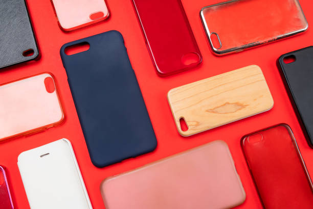 istock Pile of multicolored plastic back covers for mobile phone. Choice of smart phone protector accessories on red background. A lot of silicone phone backs or skins next to each other 1322814133