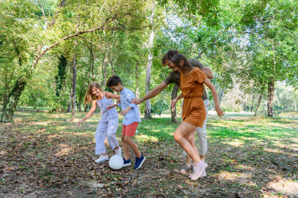 istock Happy Family is Playing With Soccer Ball in a Park. 1322816708