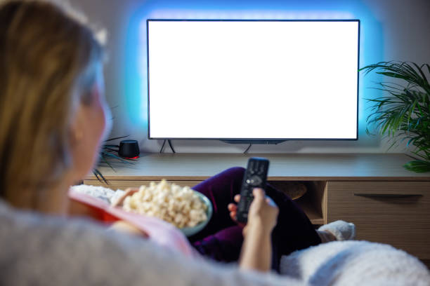 空の白いスクリードでテレビを見ている女性 - home movie ストックフォトと画像