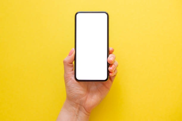 istock Mobile phone with empty screen in hand on yellow background 1322817778