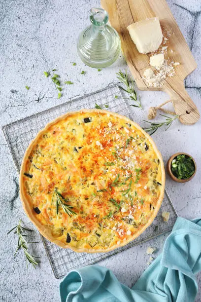 French cuisine: Zucchini and salmon quiche with parmesan cheese. Top view