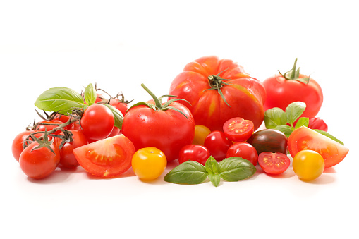 variety of tomatoes with basil on white background