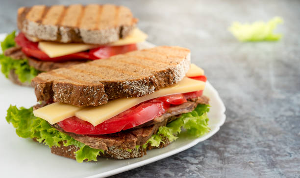istock Toast bread burger with cheddar cheese, vegetables and meat on a plate 1322819445