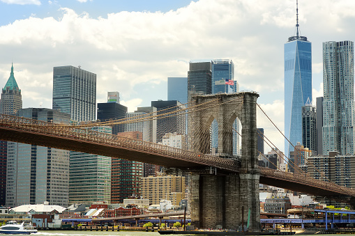 Famous Brooklyn bridge on the background of skyscrapers of Manhattan. Postcard view of New York, USA. Skyscrapers and bridges are symbol of NYC. United States of America landmarks. Sightseeing of NYC.