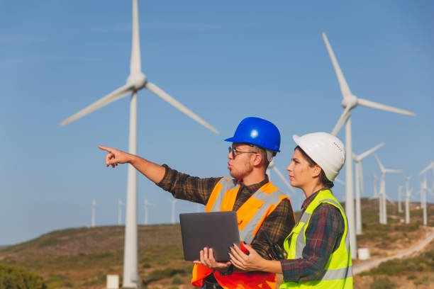 istock Young maintenance engineer team working in wind turbine farm 1322820489
