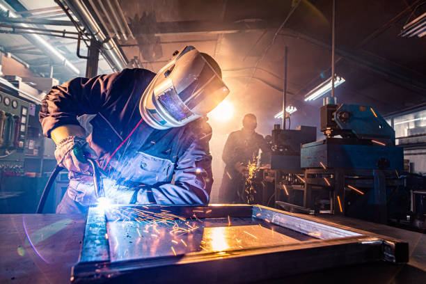 istock Two handymen welding and grinding metal at workshop 1322822546