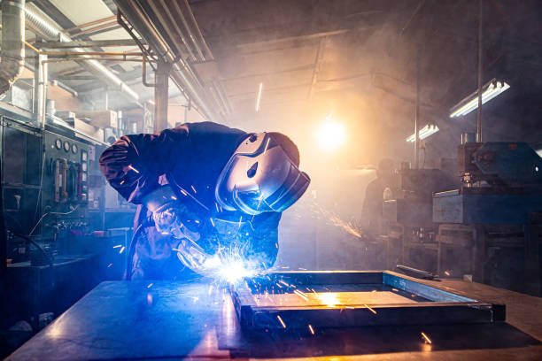 istock Two handymen welding and grinding metal at workshop 1322822576