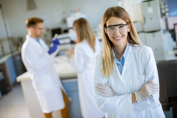 wissenschaftlerin im weißen labormantel im biomedizinischen labor - healthcare and medicine smiling group of people lab coat stock-fotos und bilder