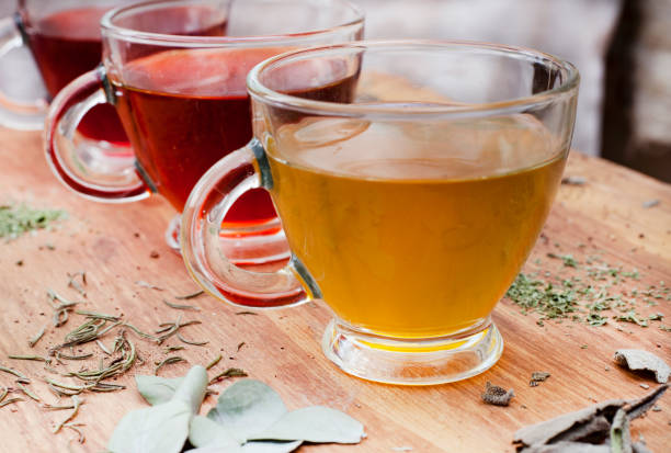 selection of herbal teas in glass tea cups shot on a dark rough textured wooden surface