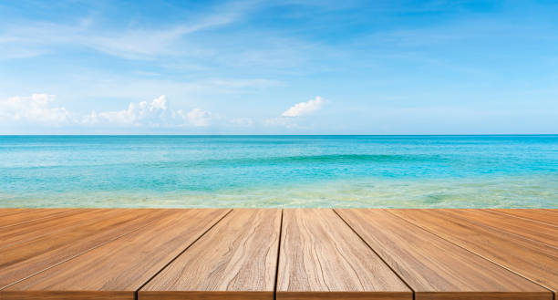 istock empty new wood table and tropical blue sea in background 1322825373