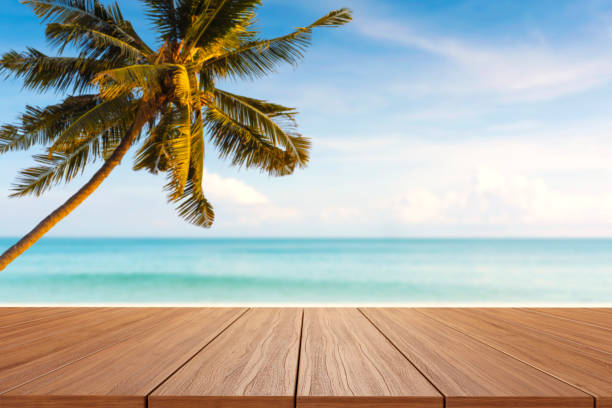 istock empty new wood table and sunset beach with coconut palm tree in background 1322825374