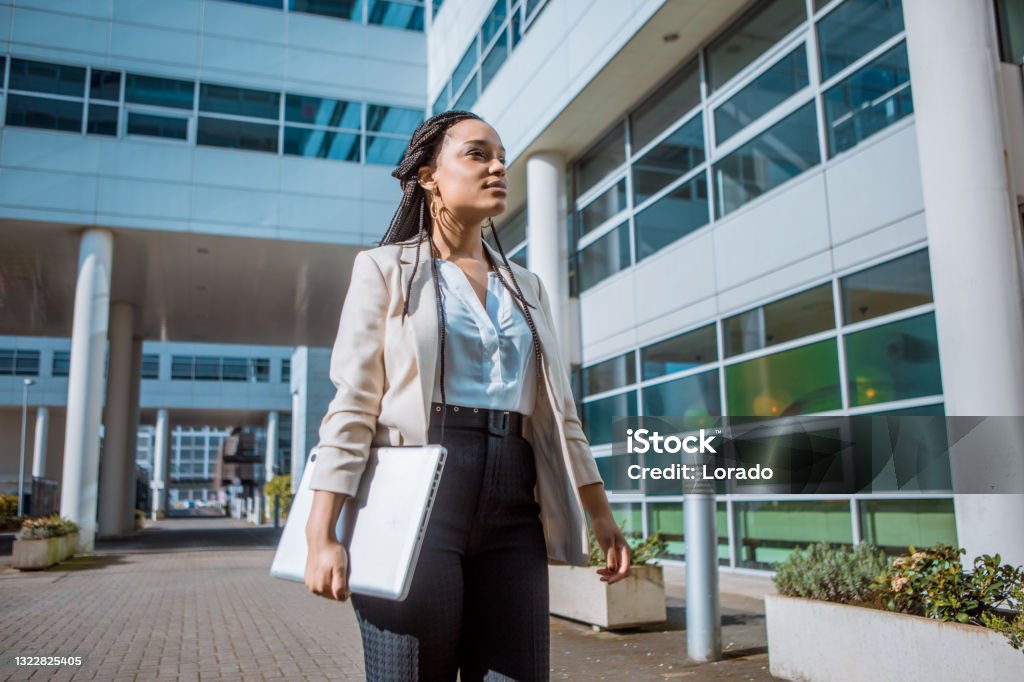 A black ethnicity female professional business woman A black ethnicity female professional business woman outdoors on an office complex in the Spring daytime Healthcare And Medicine Stock Photo