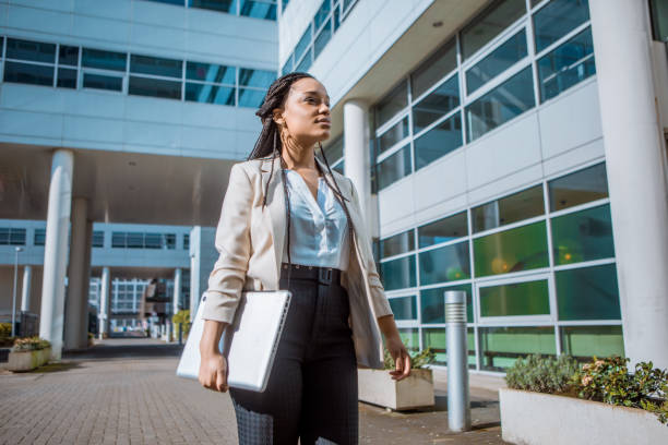 A black ethnicity female professional business woman A black ethnicity female professional business woman outdoors on an office complex in the Spring daytime businesswear stock pictures, royalty-free photos & images