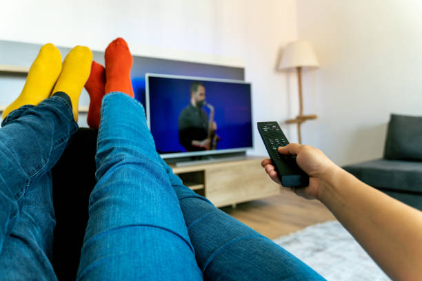 istock Young couple changing channels while relaxing on sofa at home. 1322827444