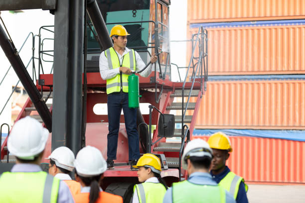 istock male engineer standing on crane car using fire extinguisher with factory workers in containers warehouse storage 1322827473