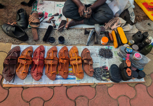 Stock photo of local Indian cobbler shop or shoe repair shop. There are number of traditional handmade chappal and shoe repair tool like leather, thread, cutter, brush, stand etc. Kolhapur, Maharashtra, India- December 5th 2020;Stock photo of local Indian cobbler shop or shoe repair shop. There are number of traditional handmade chappal and shoe repair tool like leather, thread, cutter, brush, stand etc. kolhapur stock pictures, royalty-free photos & images