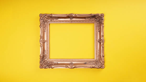 istock empty ornate gold picture frame on yellow wall background 1322829988