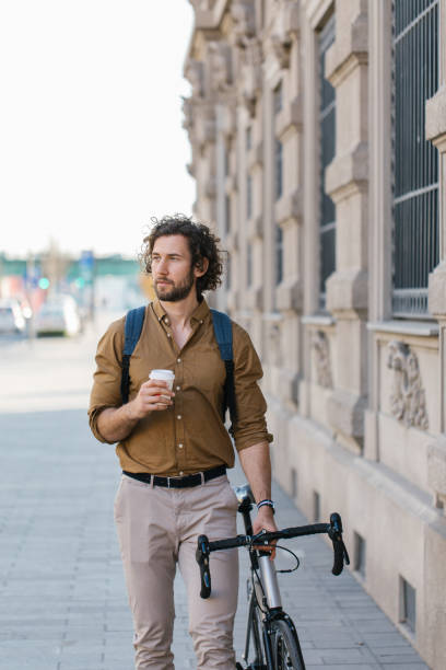 istock Handsome young businessman looking away with a coffee cup in his hand 1322832143
