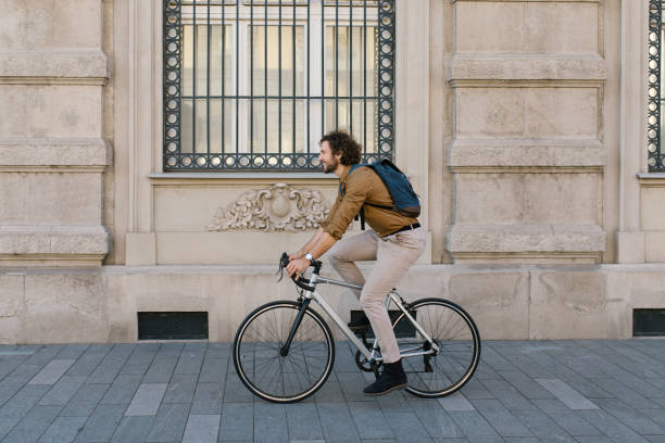 istock Side view of a handsome young businessman riding a bicycle to work 1322832172