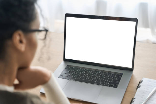 Over shoulder view of white blank empty mockup screen for advertising. Over shoulder closeup view of female student wearing glasses businesswoman looking at empty blank mockup screen for advertising, having virtual videoconference. Remote e learning online work concept. blank stock pictures, royalty-free photos & images