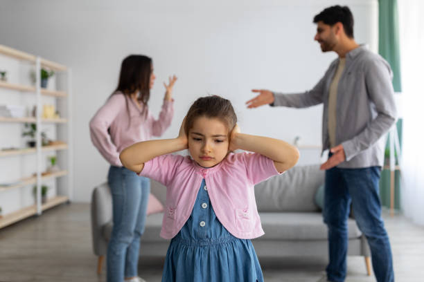 Childhood traumas concept. Upset arab girl covering ears with hands not to listen parents conflict Childhood traumas concept. Upset arab girl covering ears with hands not to listen parents conflict, innocent child suffering from family preblems, selective focus. Witnessing domestic quarrels at home man closing ears photos stock pictures, royalty-free photos & images