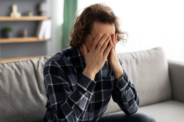 istock Unhappy Guy Covering Face Suffering From Depression Sitting At Home 1322841318