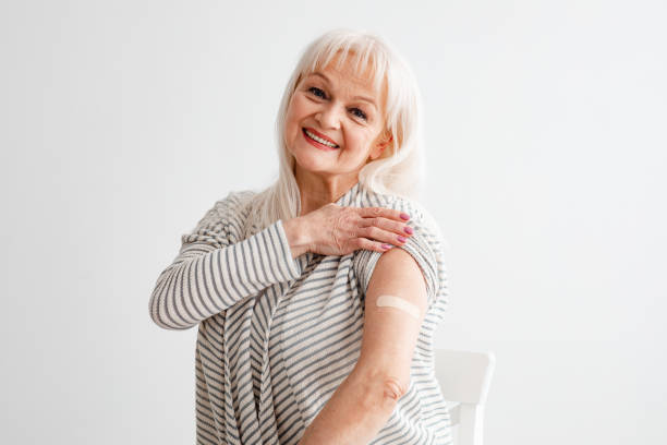 istock Mature Female Showing Vaccinated Arm After Antiviral Injection, White Studio 1322842813