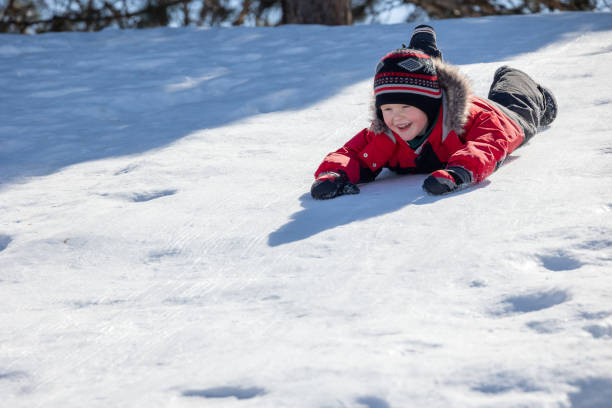 istock Little Boy Sledding on the Snow Outdoors in Winter 1322843910
