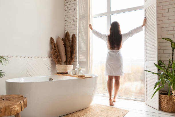 istock Woman Opening Windows In Bathroom Standing Back To Camera Indoor 1322844591