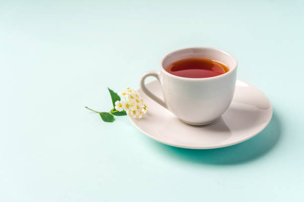 istock Beautiful minimalist background with floral composition and tea mug, copy space on light blue backround 1322845549