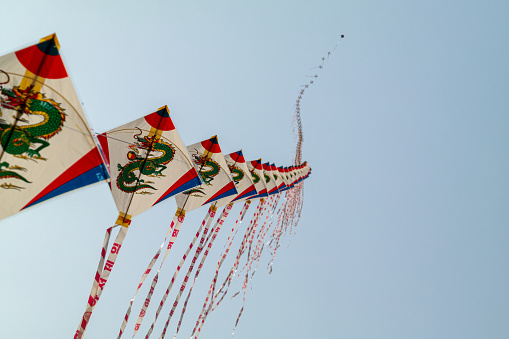 March 13, 2021, Busan, South Korea:\nMany connected kites are flying in the blue sky.